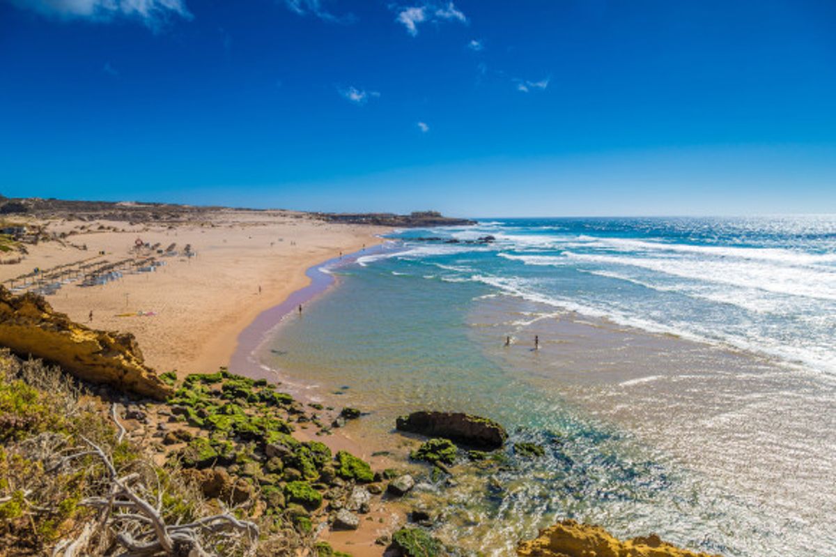 Aerial view of Praia Grande do Guincho Beach in Portugal with shimmering waters and a golden body of sand