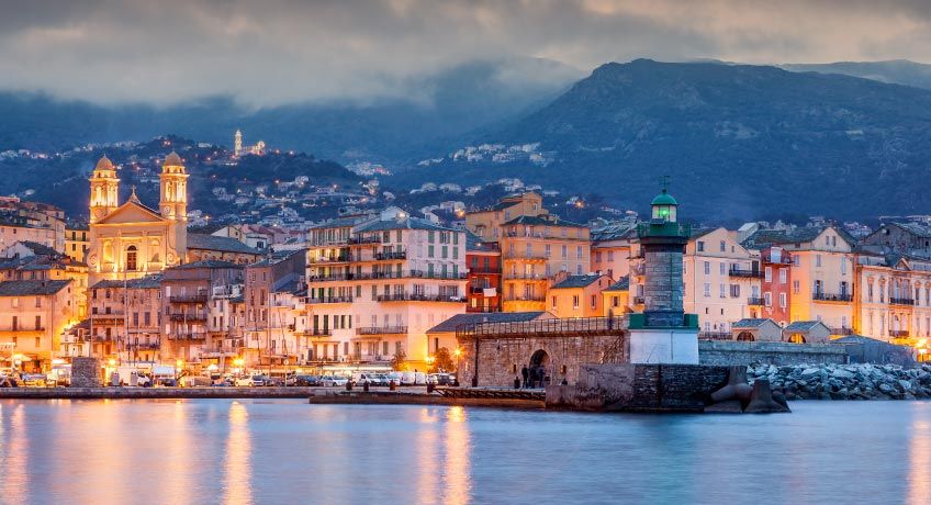 Houses all lit up alongside the harbour in Corsica