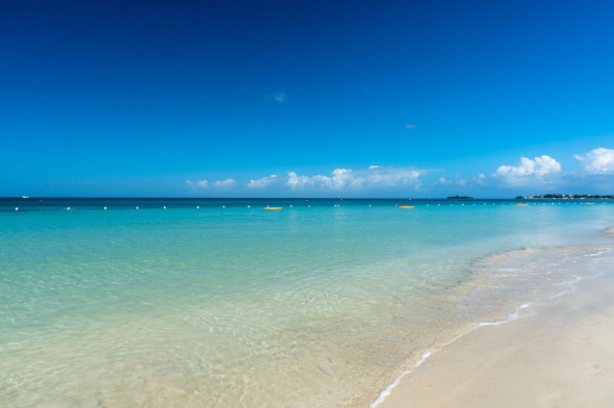 Negril's famouos seven mile beach in Jamaica with beautiful Caribbean waters backed by a bright blue sky