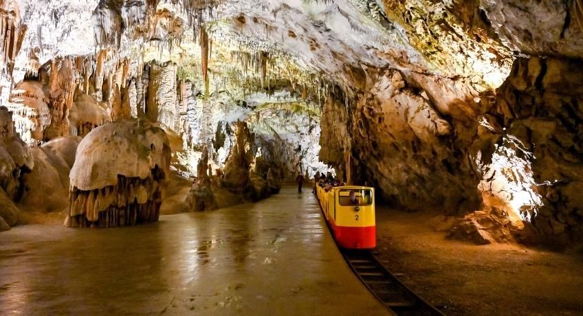 Underground cave with stalactites and a small railway