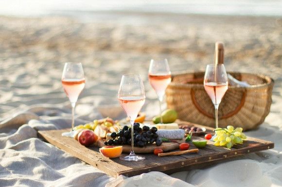 Glasses of wine and picnic on the beach