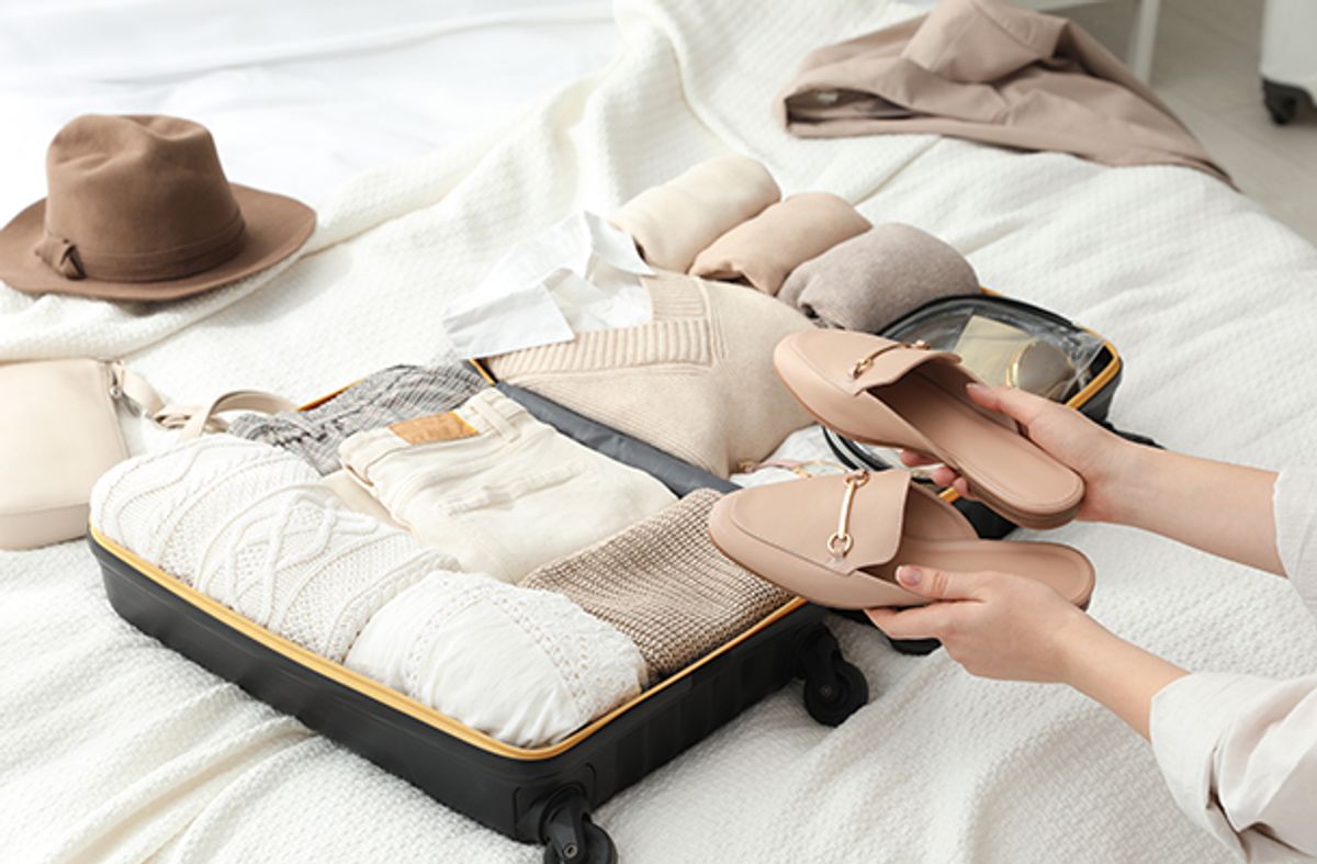 Woman packing her clothes and shoes