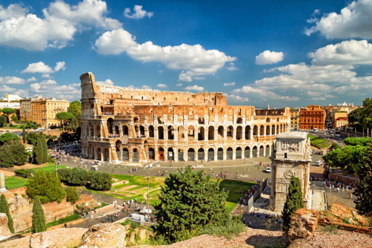 Popular tourist attraction the Colosseum in Rome on a sunny day surrounded by tourists