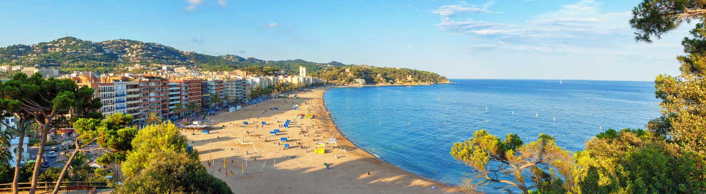 Golden sands and blue waters of a beach in Lloret de Mar, Costa Brave