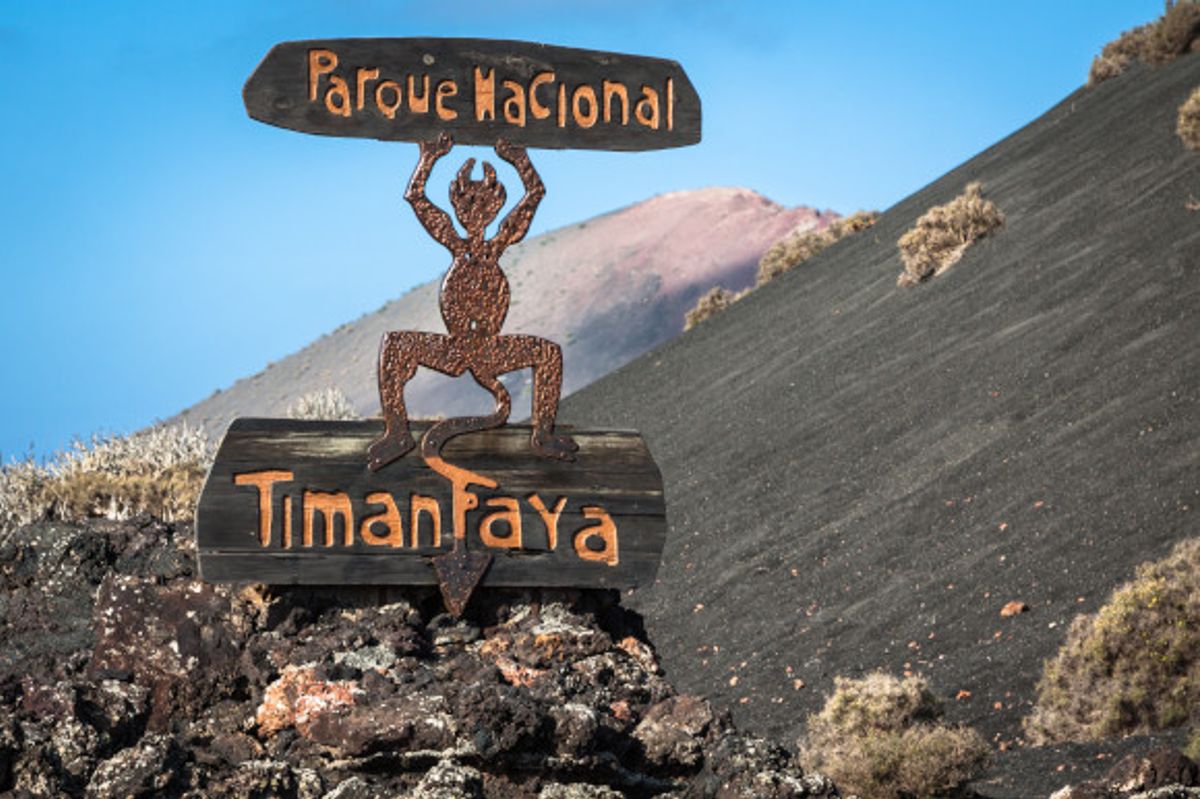The striking volcanic terrain of Timanfaya National Park on the island Lanzarote with a blue sky in the distance