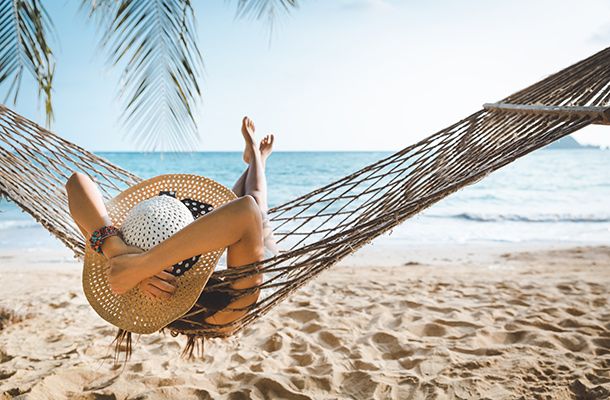 Woman relaxing in a hammock on the beach