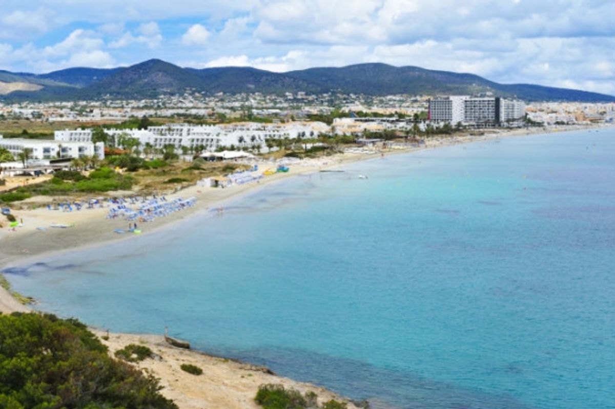 Playa den Bossa beach with views of its epic landscape and nearby hotels.