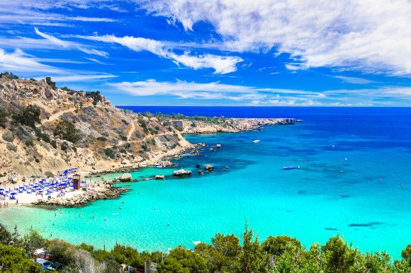 Konnos Bay in Cape Grecko national park, Cyprus surrounded by green-tinted waters and lush plant life