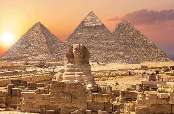 Setting sun over the Sphinx and pyramids in Egypt