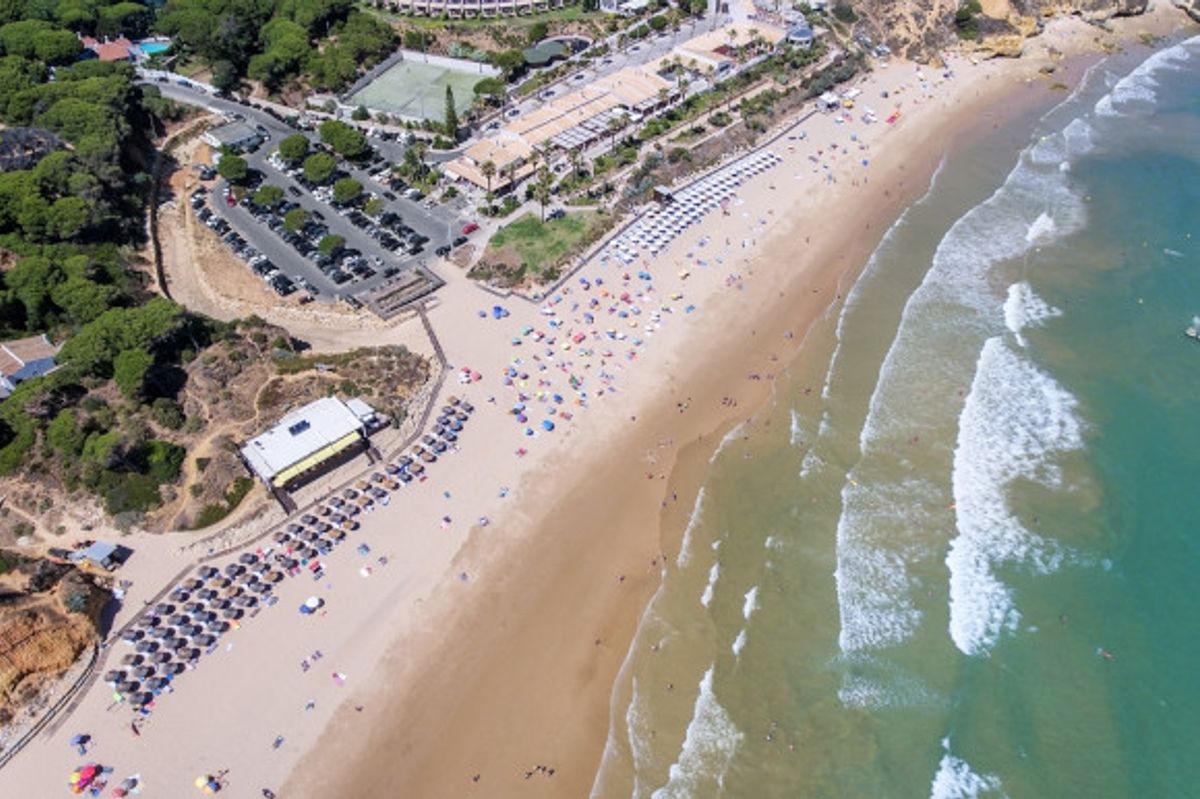 Aerial view of Olhos de Agua Beach, Albufeira in Portugal's Algarve with golden sand and emerald waters lapping the shore