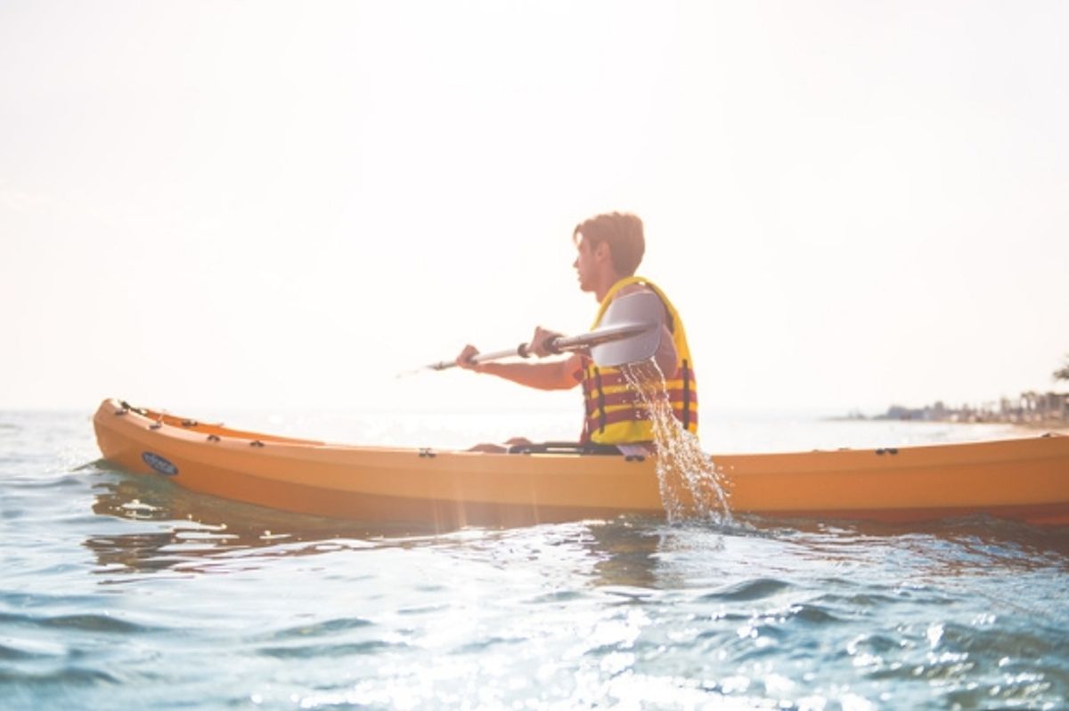 Man in a canoe on the beach surrounding Ikos Andalusia 