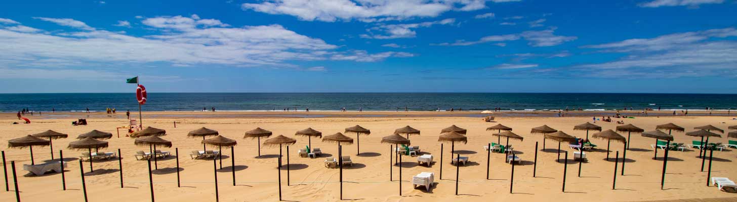 Sun umbrellas on the golden sands of Montegordo beach in the Algarve