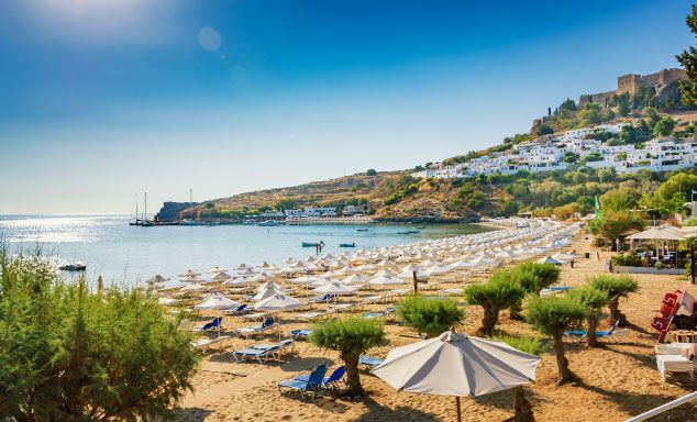 Beach in Rhodes with the town of Lindos in the background