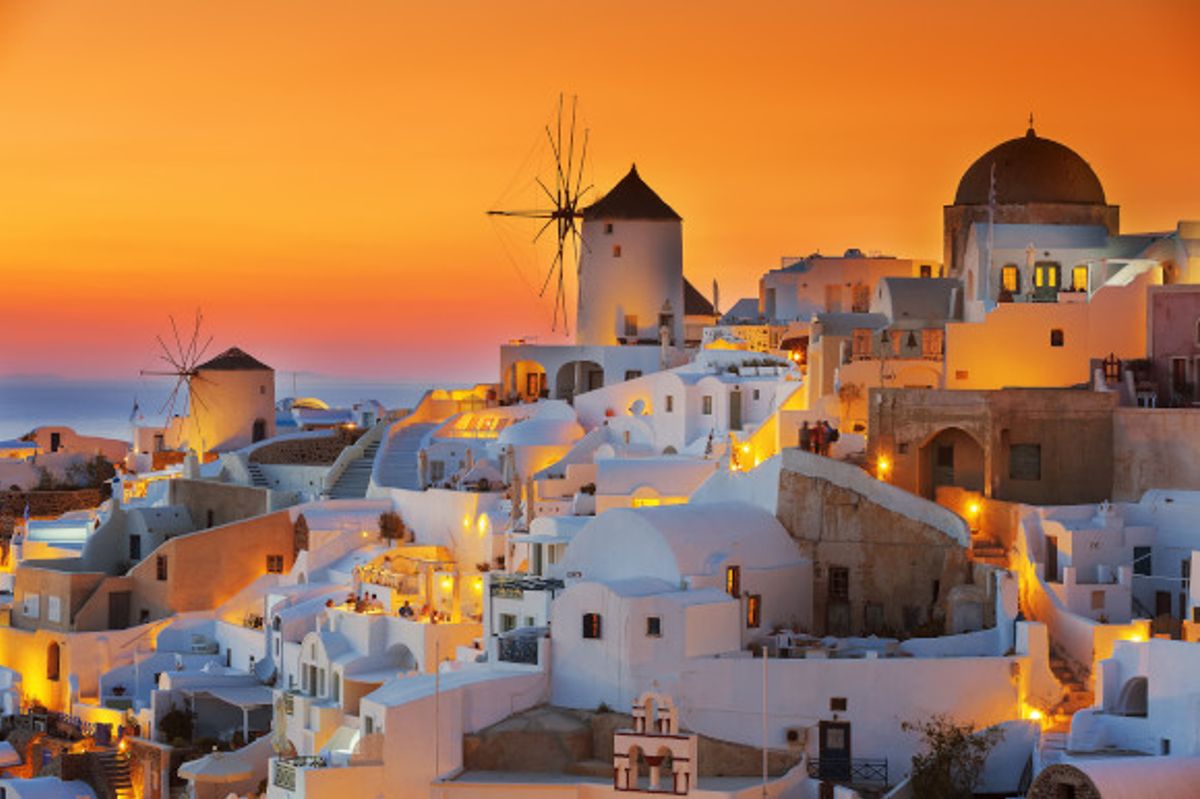 Santorini's famous sunset showing whitewashed buildings and a bright orange sky