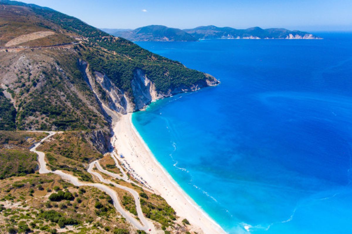 The breathtaking views from the top of Myrtos Beach in Kefalonia backed by lush green cliffs