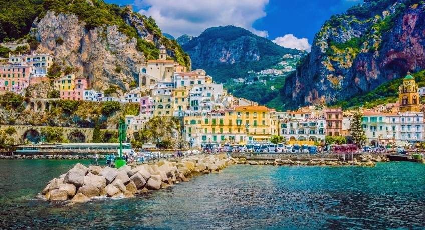 Colourful buildings in a mountainous valley with ocean waters