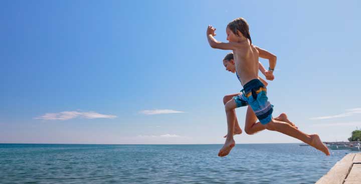 Children jumping into the sea