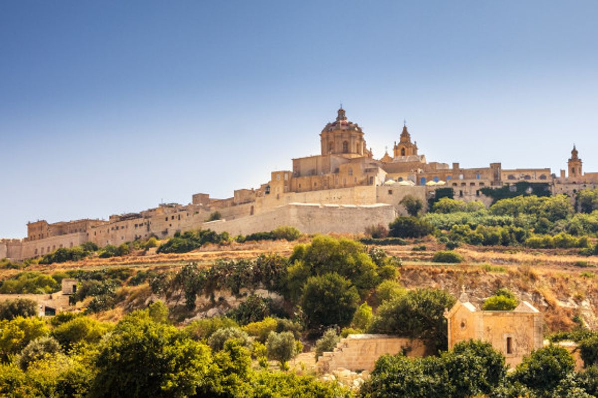 A view of the Mdina Old City and its medieval buildings against a blue sky backdrop 