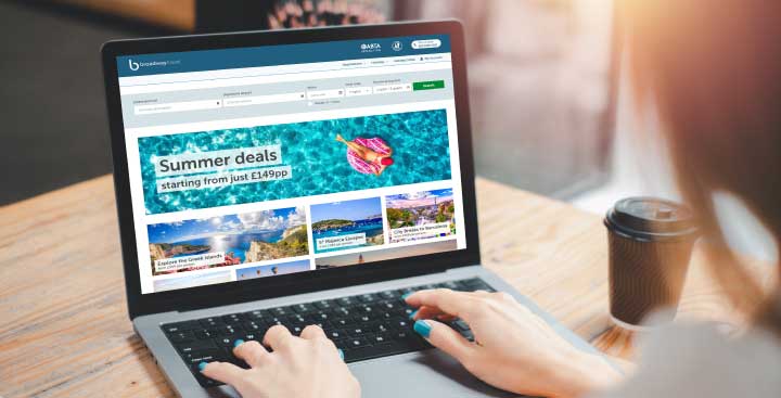 Woman looking at travel website on her laptop