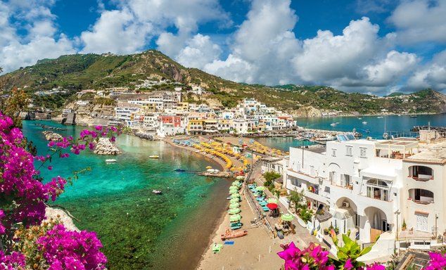 Colourful building along a beach with mountainous background