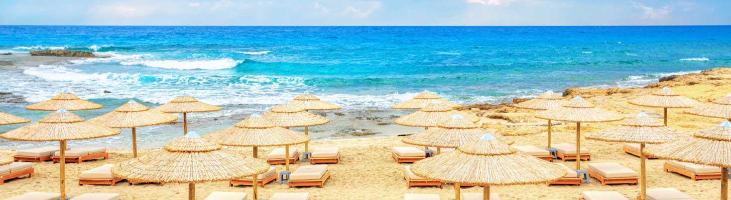 Sun umbrellas & loungers on the golden sands of Ayia Napa, Cyprus
