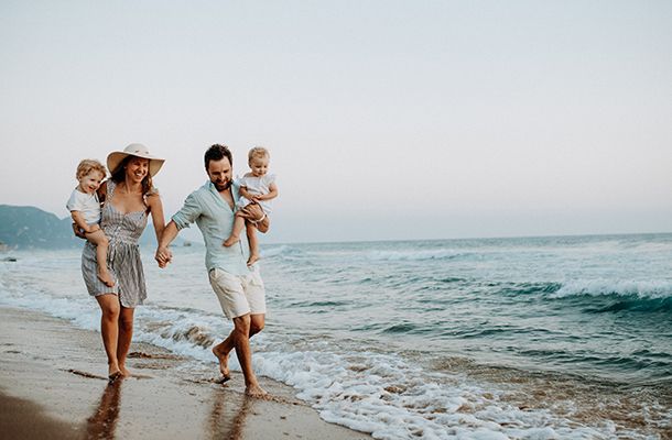 Family on beach walking through the waves