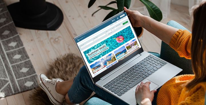 Woman looking at travel website on laptop