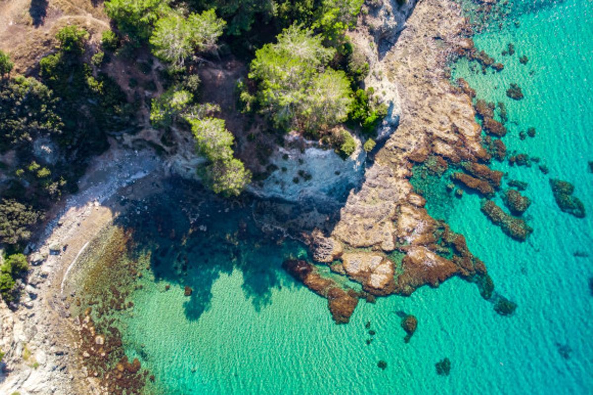 Blue Lagoon Beach in Cyprus known for its unique coloured waters with greenery and rocks surrounding the sand