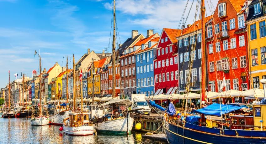 Boats & colourful buildings along the shore in Copenhagen, Denmark