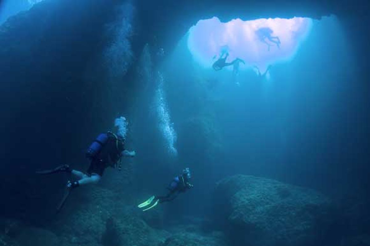 Shot of divers in the Blue Hole's underwater tunnel
