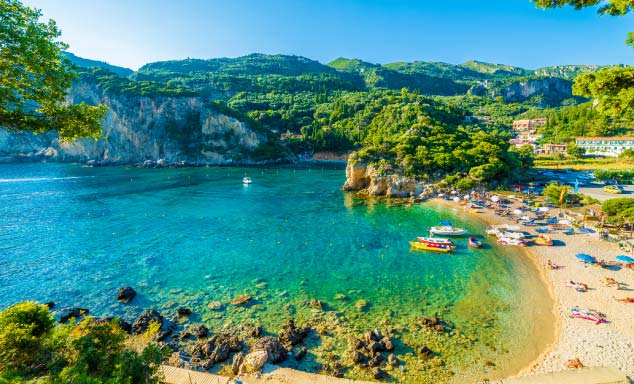 Crystal clear waters & golden sands of Paleokastritsa beach in Corfu