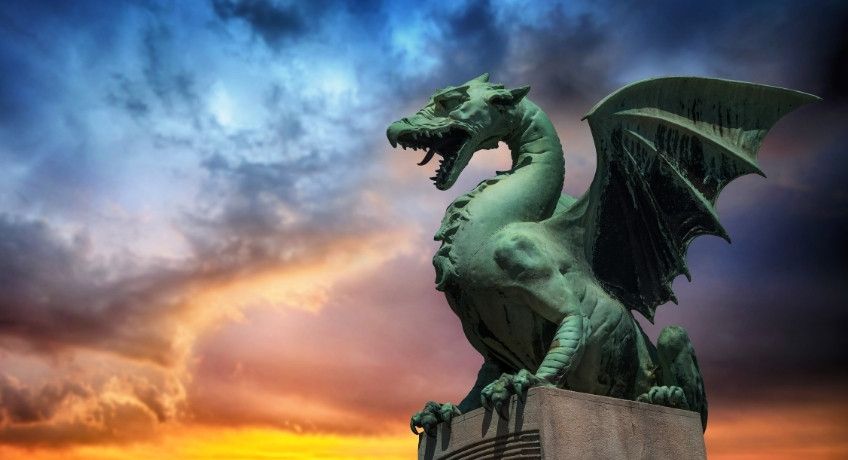 Statue of a dragon with colourful clouds in the background