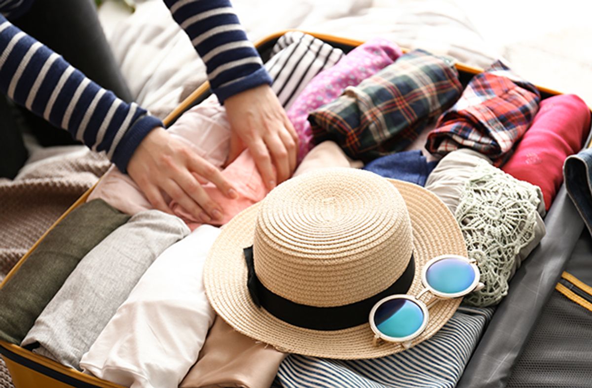 Woman rolling clothes in her luggage