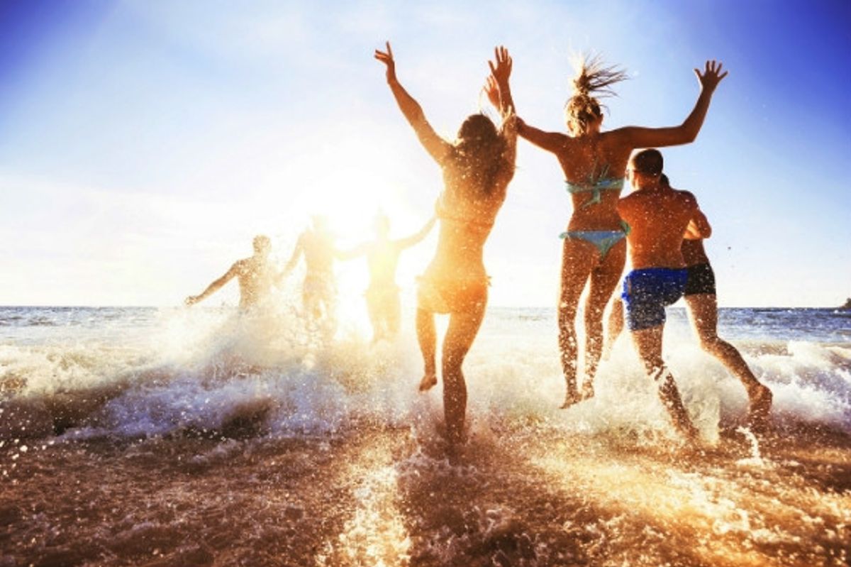 People splashing in the sea ready to go for a swim.