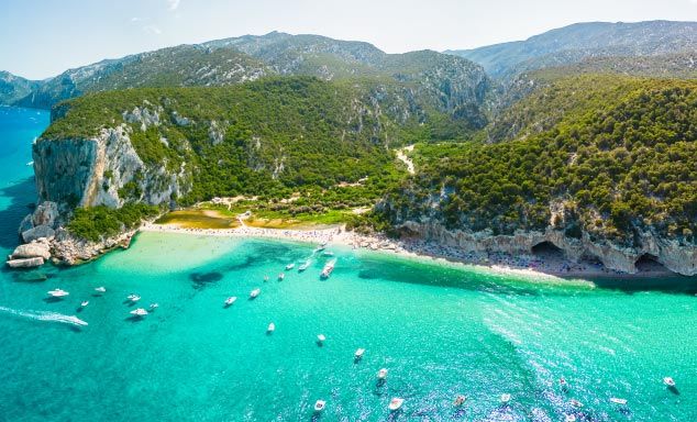 Boats in the turquoise waters at a beach in Sardinia