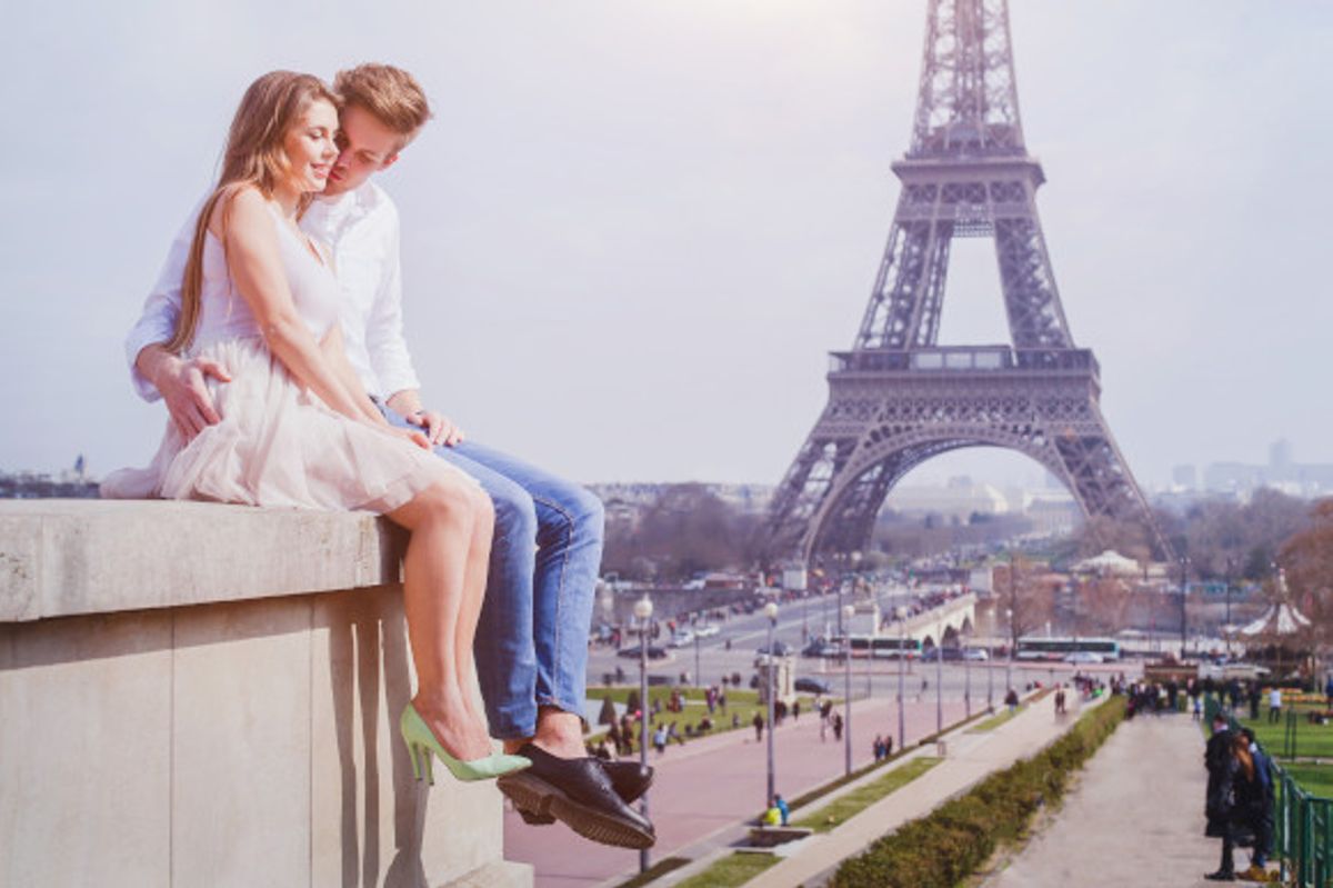Affectionate young couple in Paris with the Eiffel Tower in the background 