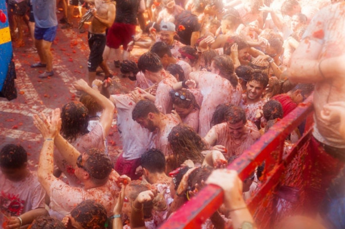 Tomatoes being shot at people during the wild La Tomatina Festival in Spain.