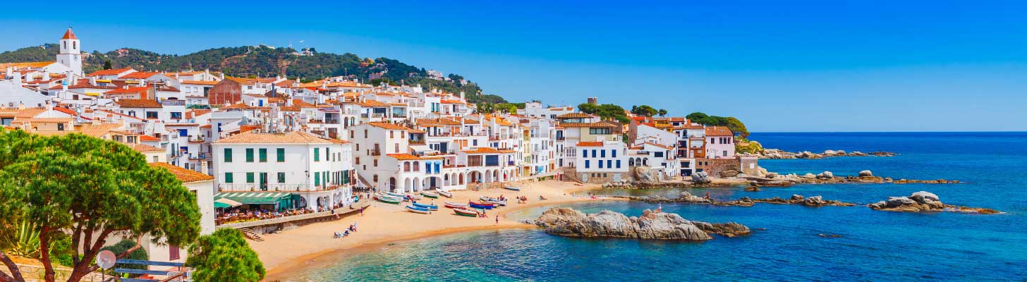 Traditional white houses line the beach in Calella de Palafrugell, Spain
