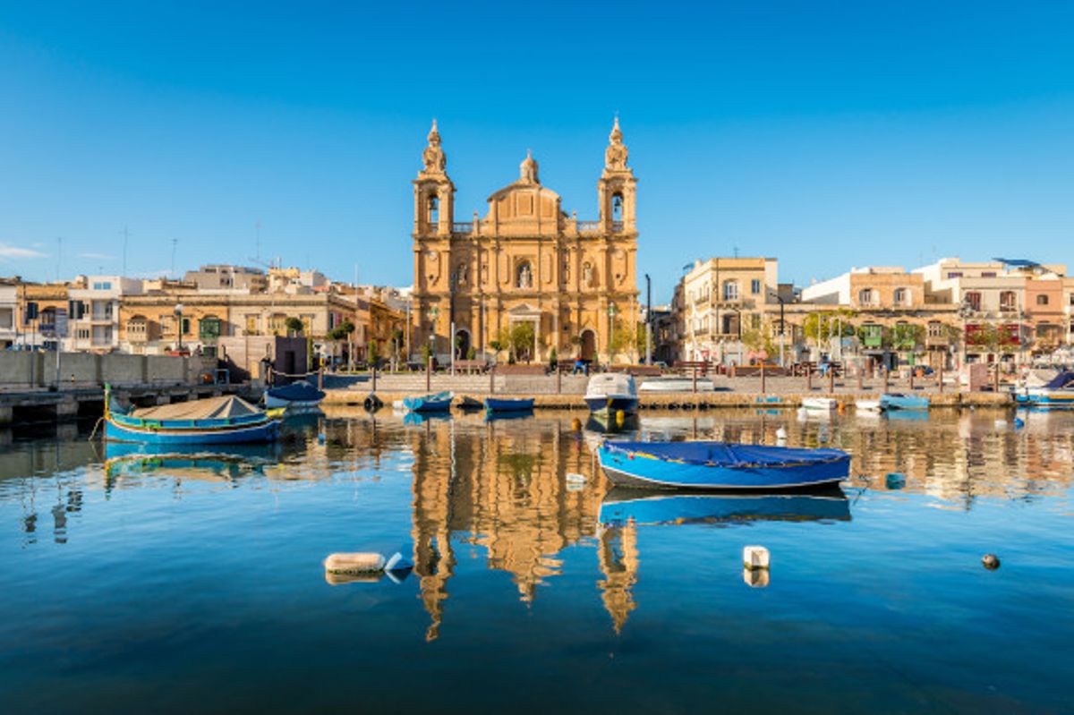Views of the church in Sliema and the surrounding waters with floating fisherman boats in Malta
