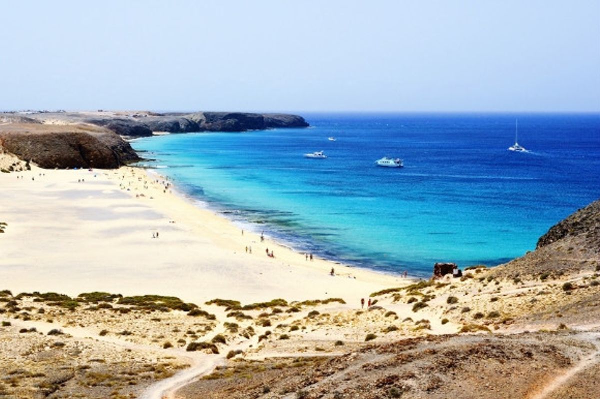 White crisp sands and sapphire Mediterranean waters of Playa Blanca beach Lanzarote