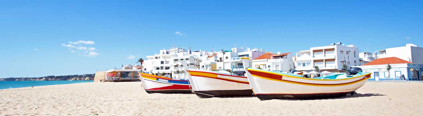 Boats on the white sand beach in Armacao de Pera, Portugal