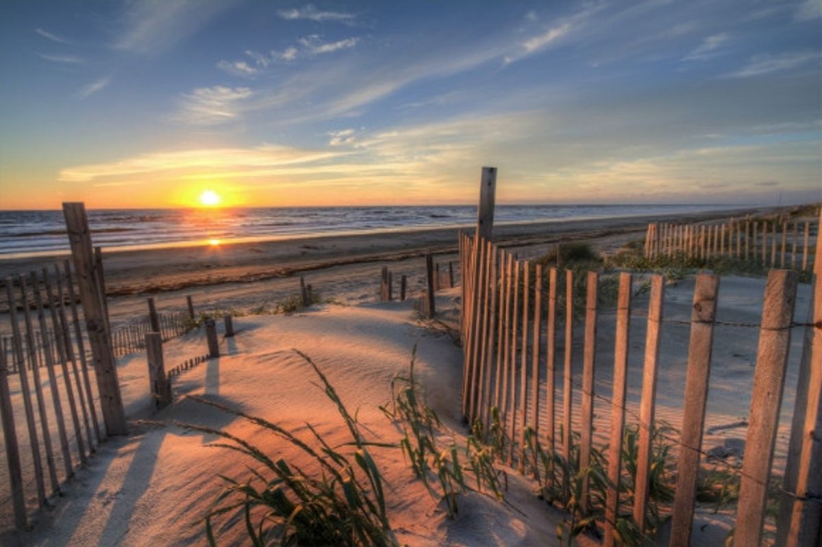 Glowing beach sunrise viewed from the beach walkway.