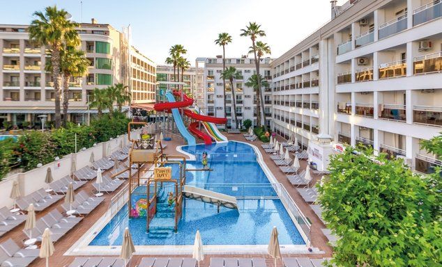 Large outdoor swimming pools with kids splash park and large waterslides located between the 5 storey hotel buildings on either side