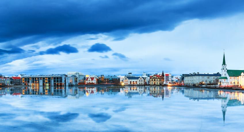 Buildings line the shores of a lake in Reykjavik