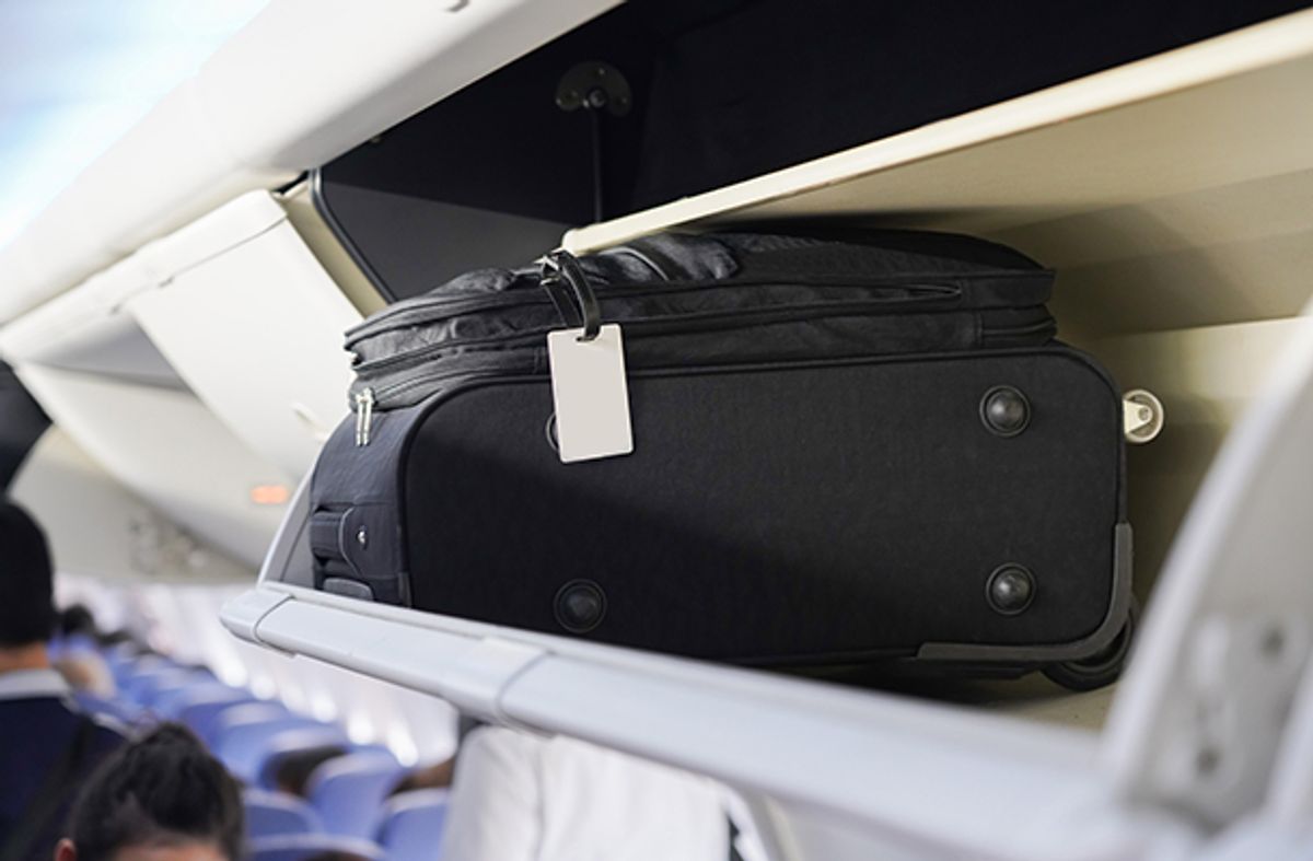 Hand luggage on an overhead shelf on plane