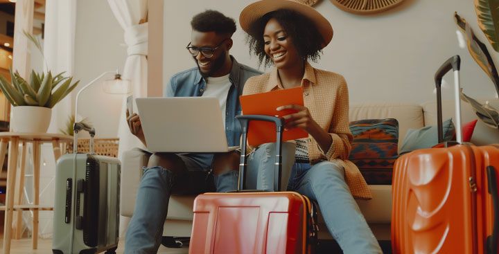 Couple with suitcases looking at laptop