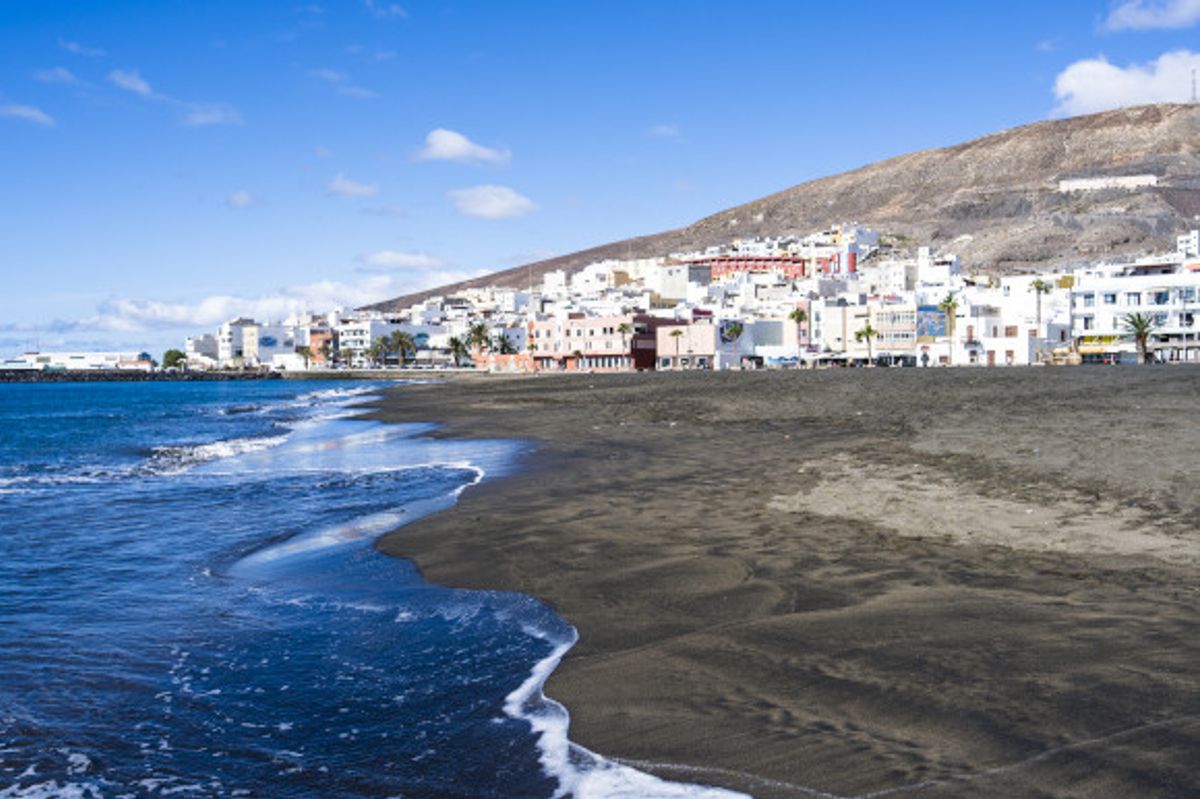 Gran Tarajal Beach in Fuerteventura with its volcanic sands and whitewashed buildings lining the shore