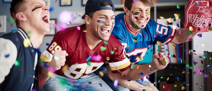 Football fans cheering on the game at home.