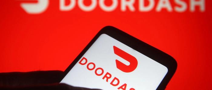 DoorDash logo and image of a hand holding a cellphone.