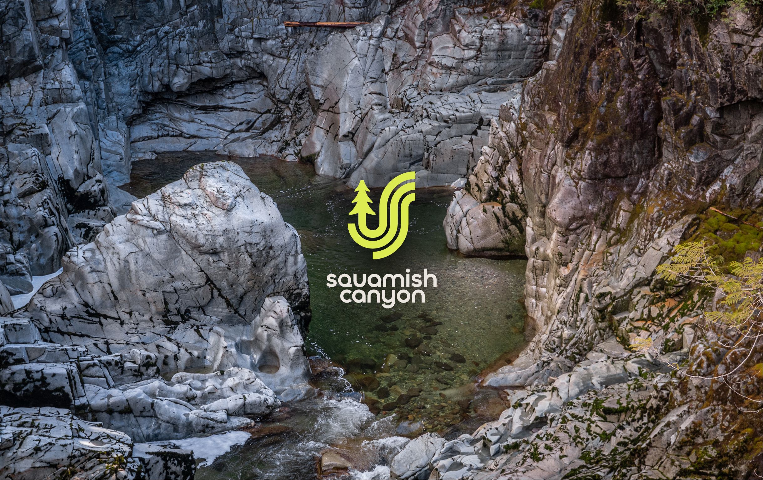 The Squamish Canyon logo over a pool in the rocky canyon